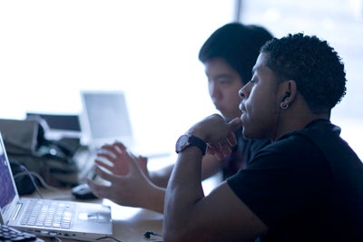 Two men looking at a laptop