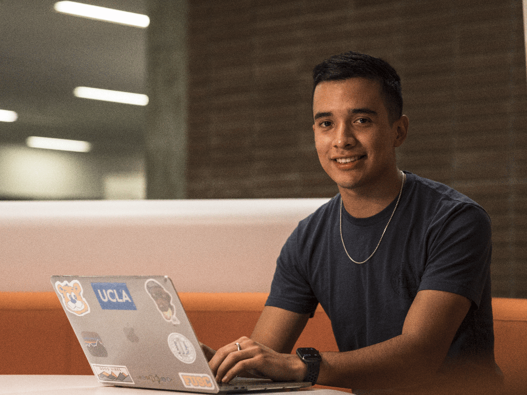 UCLA student with laptop in Charles E Young library.