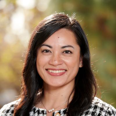 Pamela Masangkay smiling in a checked blazer, outdoor setting.