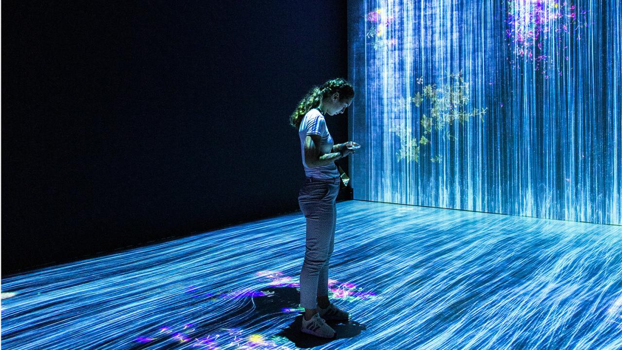 A woman standing in a projected light show.