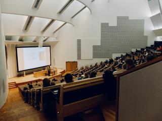 A person speaking to a crowd in a UCLA lecture hall.